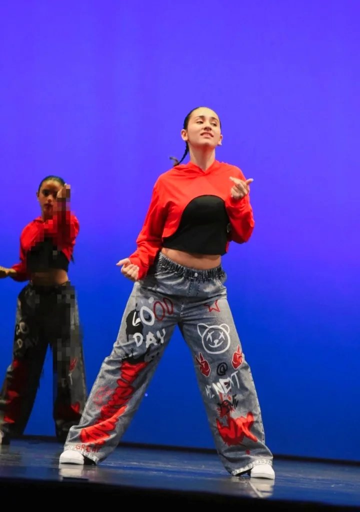 Due ballerine in rosso, nero e pantaloni decorati si esibiscono sul palco.